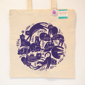 purple cats doing all kinds of things printed on a cotton tote bag
