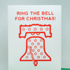 A white greeting card standing upright on a green envelope, printed with the red text 'RING THE BELL FOR CHRISTMAS!' and a red outline illustration of the Liberty Bell with stars.