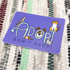 Purple card with 'Adopt Don't Shop!' text and animal illustrations on a textured fabric background