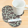Set of four geese-patterned coasters with a white mug on a wooden surface