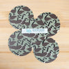 Set of four circular coasters with Canada goose pattern on a wooden surface