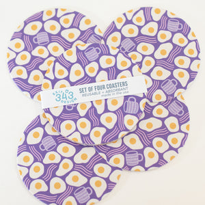 Set of four purple coasters with egg pattern.