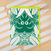 Green and white patterned card on a wooden surface