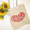Beige tote bag with 'CHICAGO' print and sunflowers on a white background