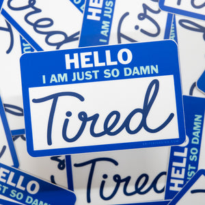 Sticker with 'HELLO I AM JUST SO DAMN Tired' text on a blue border, surrounded by similar stickers.