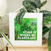Framed print with 'Home is where my plants are' text in a room with plants