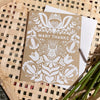 Decorative card with 'Many Thanks' on kraft paper against a woven background