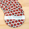 Set of four ladybug pattern coasters with a label on a wooden surface