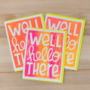 Three colorful greeting cards with 'Well hello there' text on a wooden surface