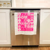 White towel with pink floral patterns hanging on a kitchen appliance.