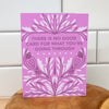 Purple card with text and bird illustrations on a wooden surface