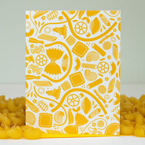 Yellow pasta patterned box with pasta on a white background