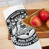 Towel with 'Rooted in Philadelphia' design on a wooden surface with apples.
