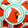 Sticker with a cardinal design and 'Union of Backyard Birdwatchers' text on an orange background.